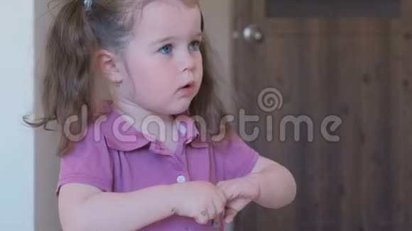 小可爱的女孩涂着蓝色清漆的指甲视频的预览图