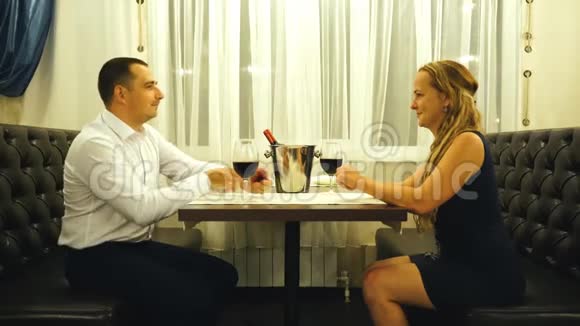 餐厅情侣和度假的概念兴奋的年轻女人在餐厅看着带订婚戒指的男朋友视频的预览图