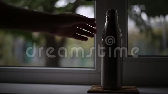 窗户背景上的水用钢制热瓶视频的预览图