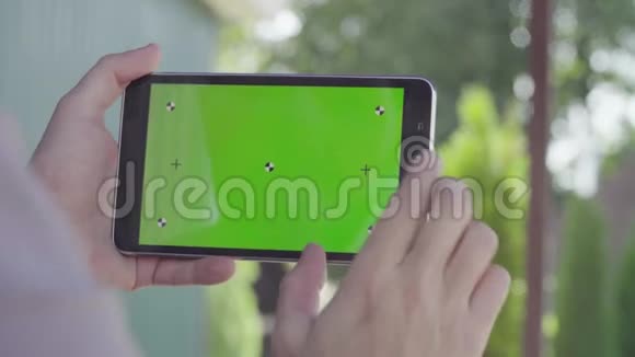 男性手拿着绿色屏幕的平板电脑视频的预览图