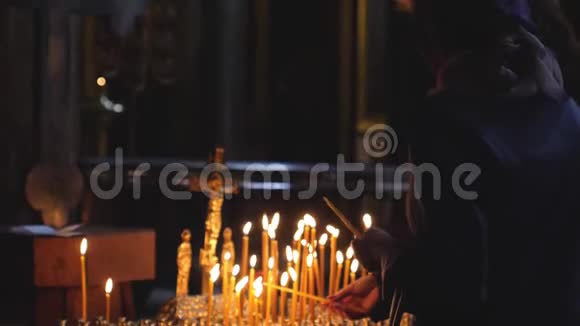 妇女在圣彼得堡教堂缓慢地祈祷和燃烧蜡烛1920x1080视频的预览图