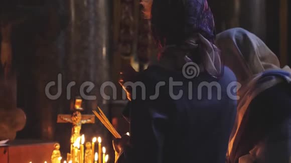 女人缓慢地祈祷在圣彼得堡教堂点燃蜡烛3840x2160视频的预览图