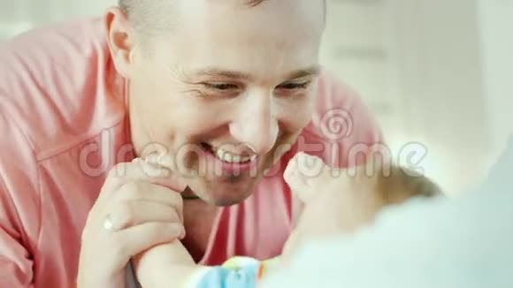 一个年轻父亲的笑脸赞赏和微笑看着她的孩子视频的预览图