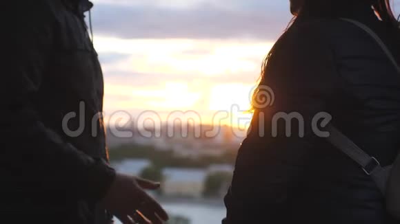 亲密的两个情人携手恋爱中的情侣牵着手看着城市的日落幸福快乐视频的预览图