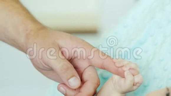宝贝拿着他父亲的手指两个月的男孩躺在床上视频的预览图