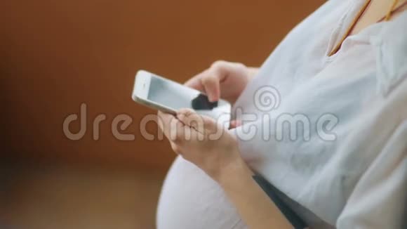 在智能手机StediCam慢动作视频中观看媒体内容的孕妇视频的预览图
