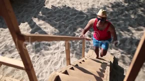 在海滩树屋上爬梯子的人视频的预览图