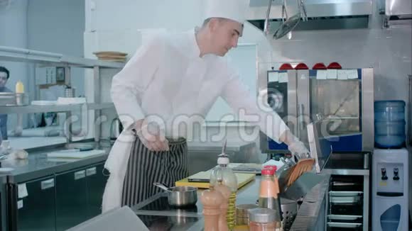 厨师用刀在砧板上切大蒜并将其与另一位厨师带来的盐混合视频的预览图