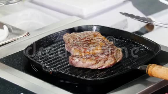餐厅厨房厨师在平底锅里煎牛排视频的预览图