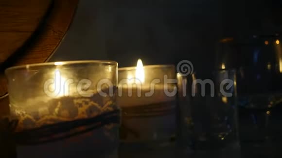 在浪漫的夜晚烛光下用木桶装着白兰地玻璃慢动作视频的预览图