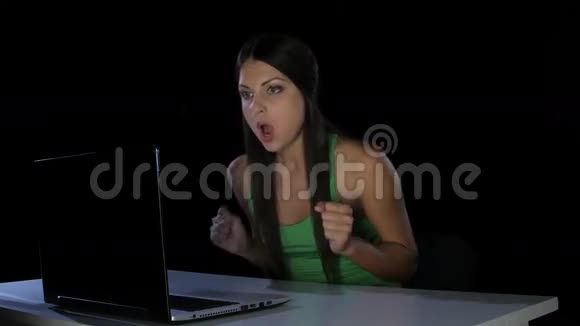充满热情的女孩坐在笔记本电脑前情绪激动工作室视频的预览图