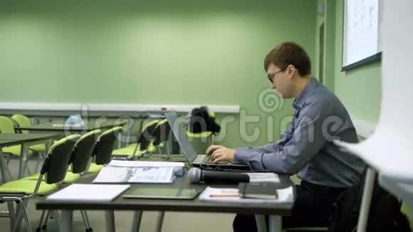 讲师讲课前打印讲稿戴眼镜的年轻人空着手提电脑视频的预览图