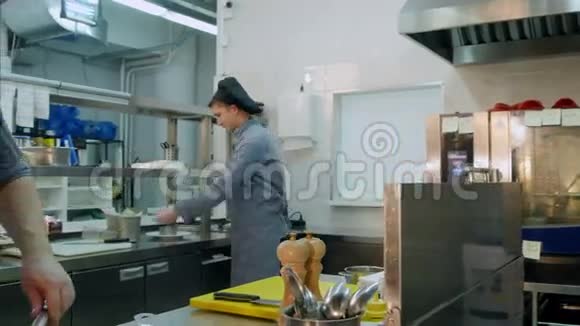 三个忙碌的男厨师在餐厅厨房工作视频的预览图