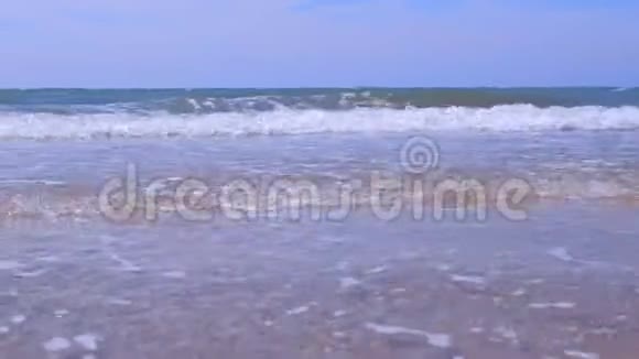 在阳光明媚的日子里沙滩上的海景和大海有着长长的大浪视频的预览图