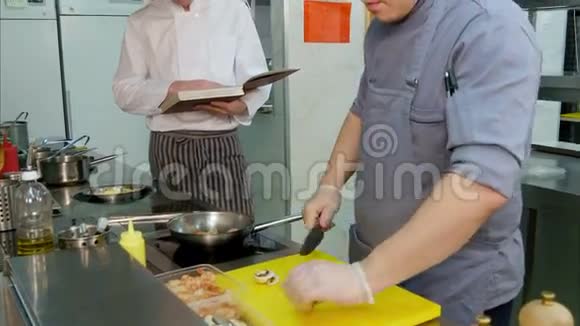 厨师带食谱看小厨师在厨房准备菜视频的预览图
