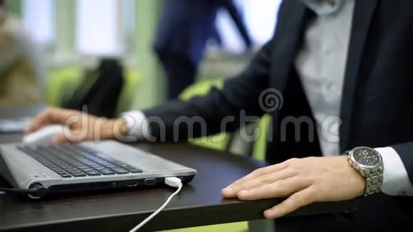 在笔记本电脑上工作时用良好的手表关闭男性的手在键盘上键入一些东西并使用鼠标青年视频的预览图