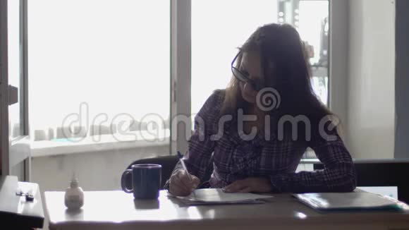 女商人戴着眼镜在笔记本电脑上工作喝咖啡慢动作3840x2160视频的预览图