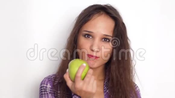 健康的微笑年轻的黑发女人吃绿色苹果慢动作3840x2160视频的预览图
