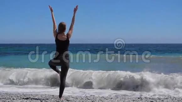女孩在海边练习瑜伽慢动作高清视频视频的预览图