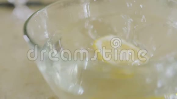 一片柠檬在慢动作中与水一起掉进碗里视频的预览图