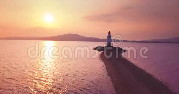 日出时在沙质上空飞行至托卡列夫斯基灯塔其鸟瞰图视频的预览图