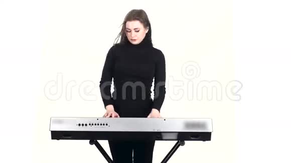 穿着深色衣服的钢琴师在合成器上演奏白色背景视频的预览图