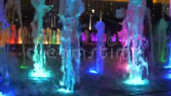 晚上在城市街道上近距离观看美丽的彩色喷泉视频的预览图