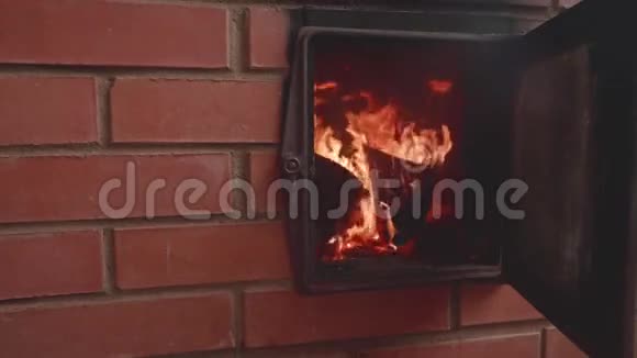 壁炉里的火焰男人手关上壁炉的门慢镜头视频的预览图
