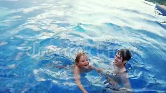 快乐的少年男孩和父亲一起笑在游泳池慢动作1920x1080视频的预览图