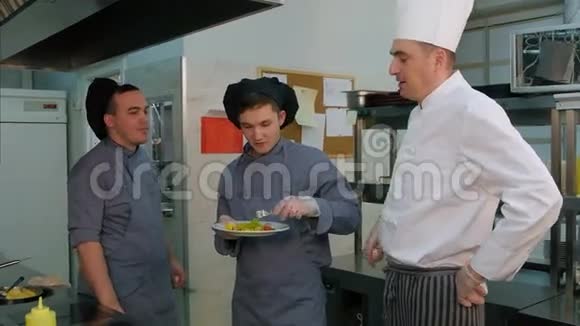 年轻的男性厨师尝试着做厨师做的虾沙拉并讨论它视频的预览图
