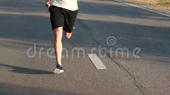在沥青路面上奔跑的人培训慢动作视频的预览图