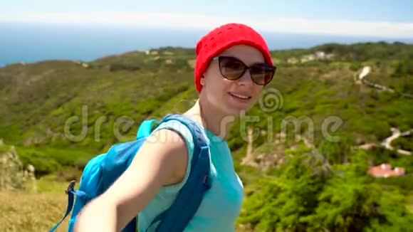 背着背包的女人把手递给她的同伴她站在海边的一座小山上视频的预览图