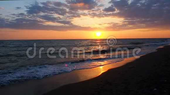 美丽的日落在海滩惊人的颜色光束通过云景海景在日落海浪视频的预览图