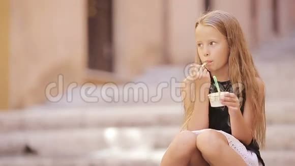 可爱的女孩在欧洲城市户外吃冰淇淋可爱的孩子在罗马享受真正的意大利冰淇淋视频的预览图