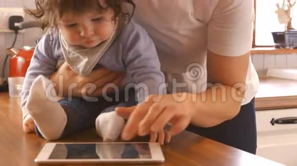 妈妈在给宝宝换尿布时用数码平板电脑视频的预览图