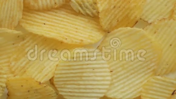 不健康的有害食物黄色美味的土豆肋脆片随机躺在白色的桌子背景上特写镜头m视频的预览图