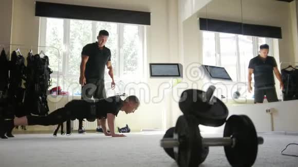 肌肉健身教练与穿着EM服的运动员合作视频的预览图