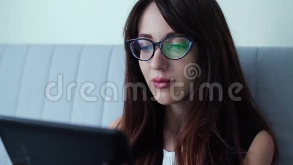 商务女性带平板电脑坐在沙发上视频的预览图