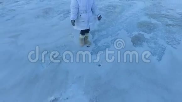 女孩离开冰冻的湖孩子失望地回家了女孩想在冰上散步视频的预览图