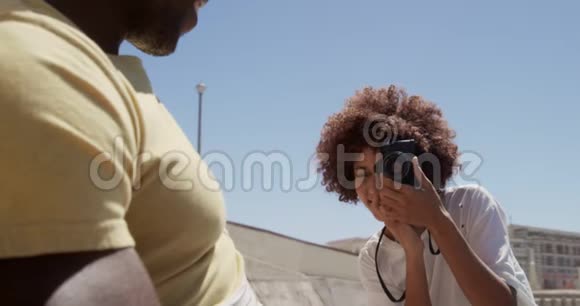 女子在沙滩上用数码相机拍照视频的预览图