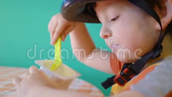 运动头盔中可爱的小男孩在训练前吃酸奶视频的预览图
