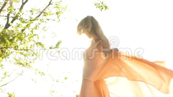 美丽的金发女人在森林里旋转视频的预览图