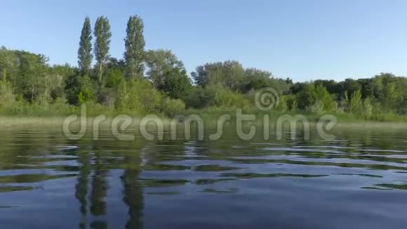 在帆船上的录像俄罗斯伏尔加河沿着有绿色植被的海岸或岛屿移动视频的预览图