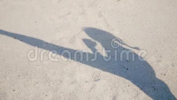 在沙滩上你可以看到影子一个运动女孩的轮廓她举起腿完成了视频的预览图