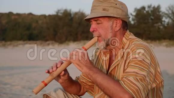 日落时分老人在海滩上吹竹笛视频的预览图