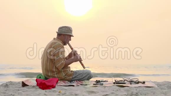 日落时分老人在海滩上吹竹笛视频的预览图