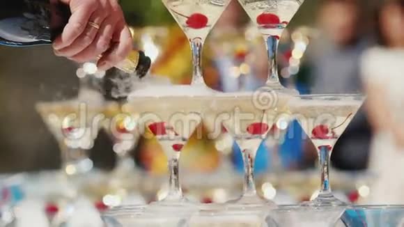 带香槟的金字塔玻璃在背景中服务员把酒倒进杯子里户外活动视频的预览图