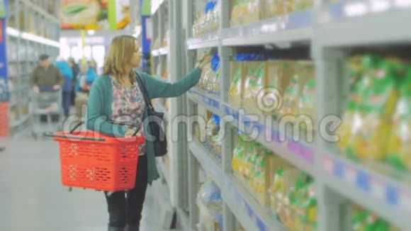 年轻的女人在超市里选择食物母亲在市场上为孩子选择食物女孩站在附近视频的预览图