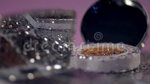 细小的颗粒落在镜框里的化妆品上视频的预览图