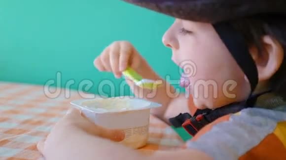 运动头盔中可爱的小男孩在训练前吃酸奶视频的预览图